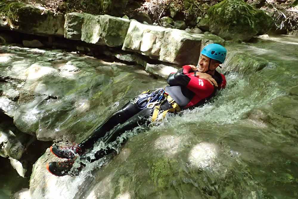 homme qui glisse au canyoning angon