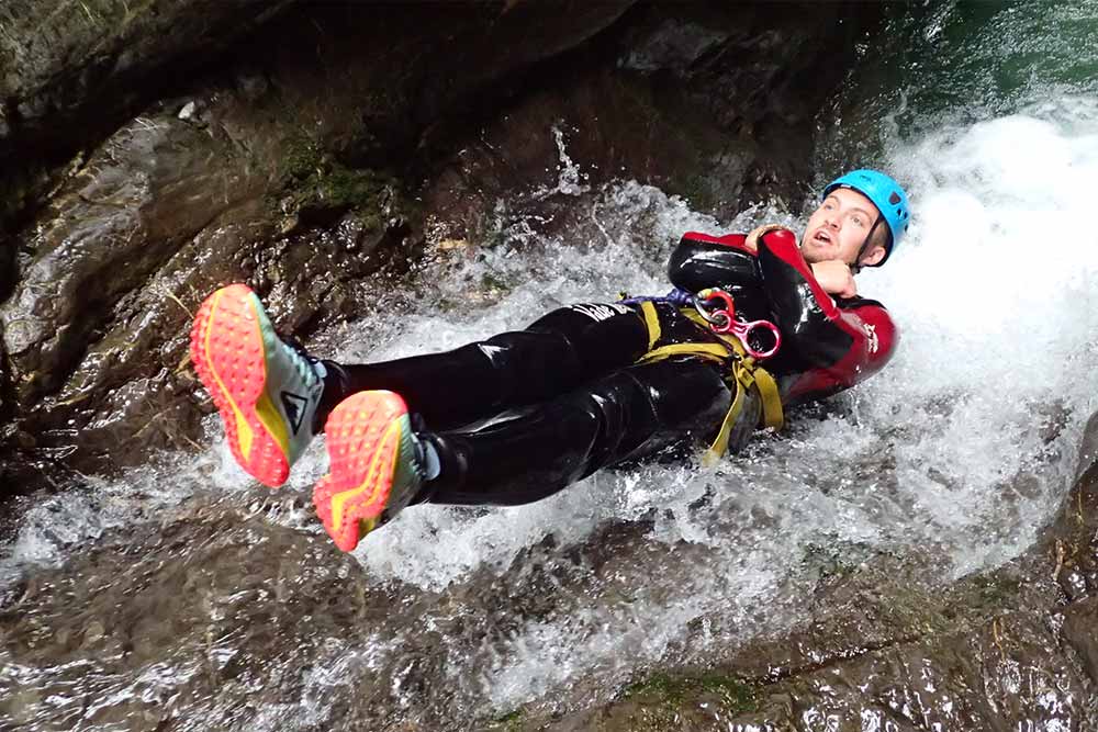 homme en toboggan tête en bas canyoning annecy