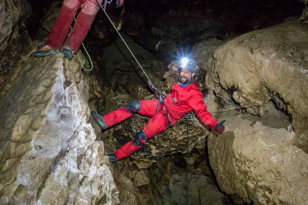 homme qui descend en rappel en spéléologie à annecy