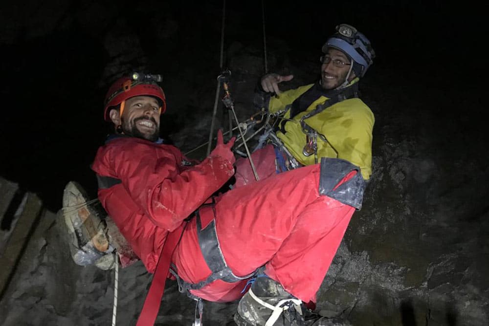 deux hommes remontent sur corde en spéléologie en haute savoie