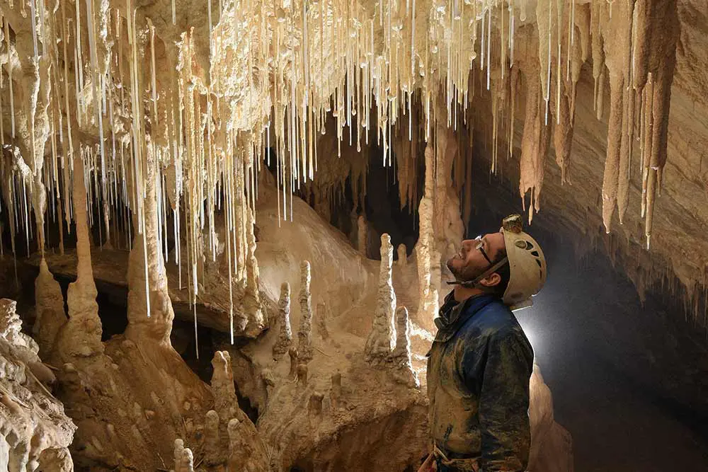 homme qui regarde des formation géologique en spéléologie à prérouge