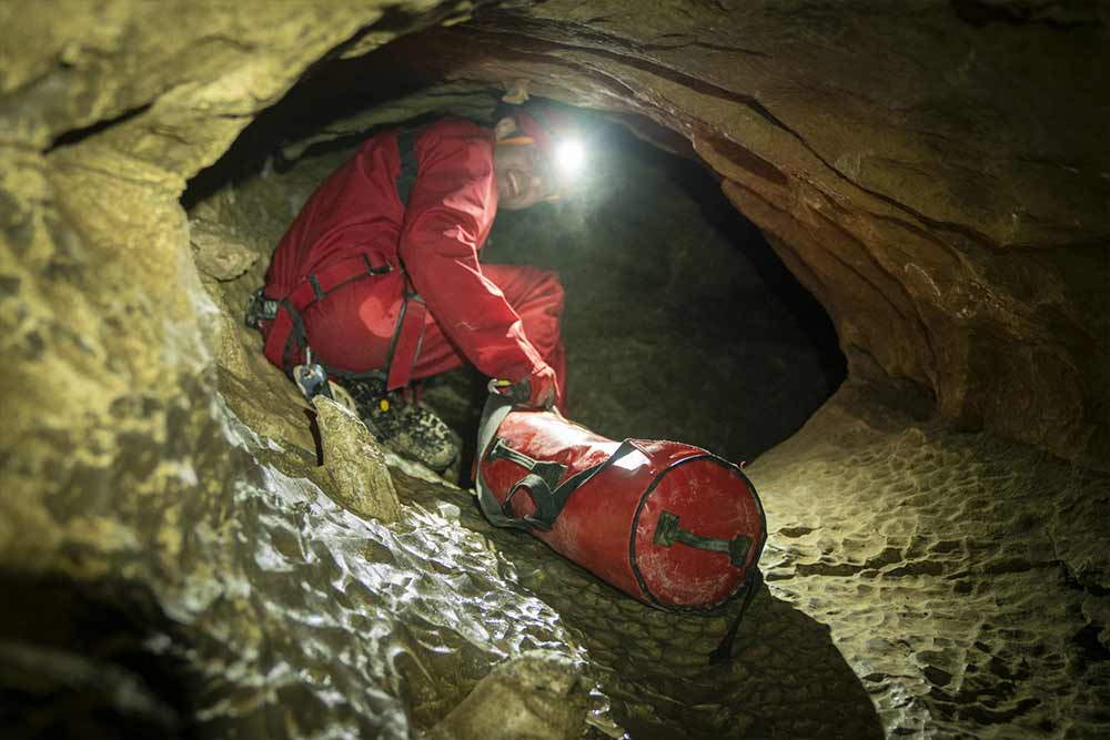 homme qui tire un sac en spéléologie à annecy