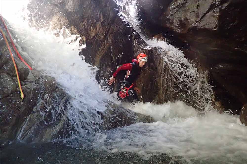 homme dans une cascade canyoning eaux rousses