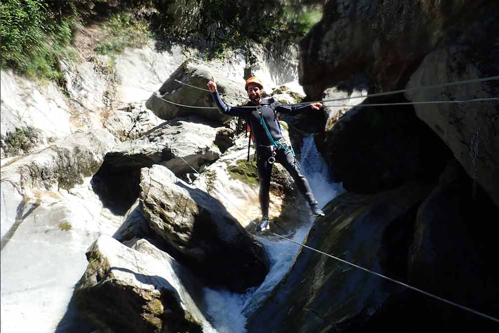 homme sur un pont de singe canyoning des eaux rousses