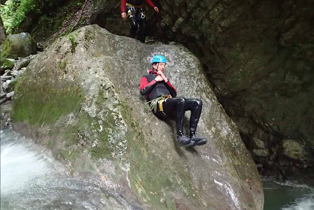 homme qui glisse sur un toboggan en canyoning a geneve