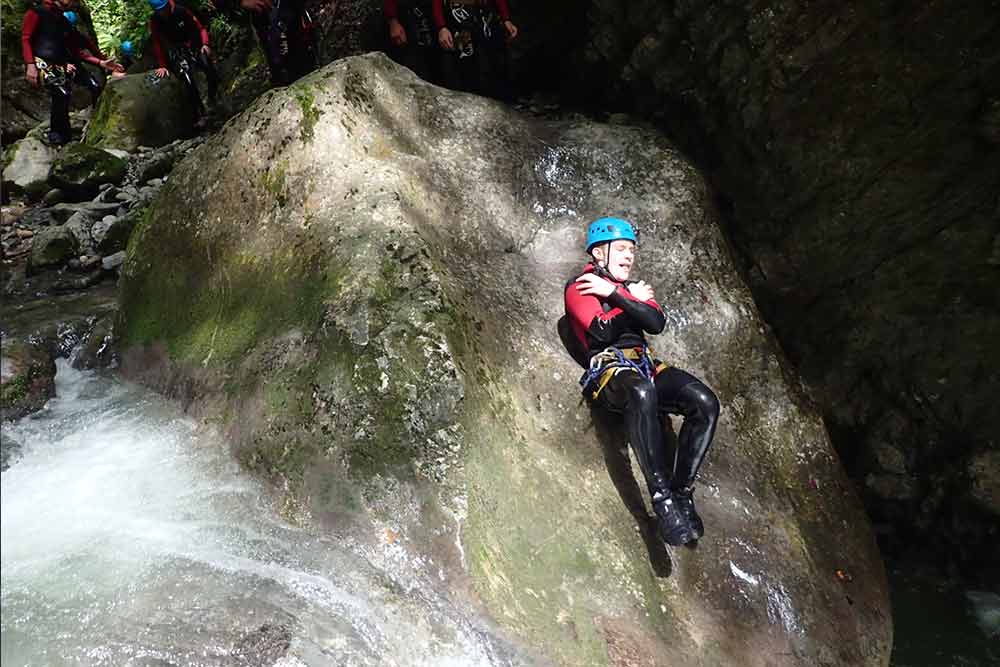 enfant qui glisse en descente canyoning Talloires