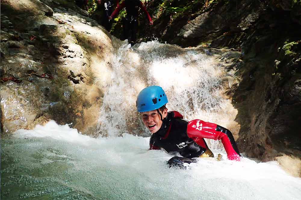 enfant dans une cascade en canyoning aux menuires